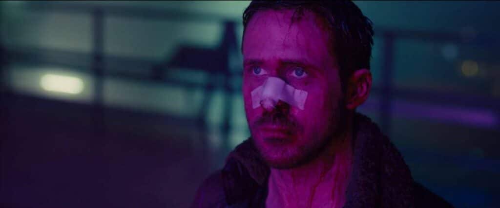 Ryan Gosling in Blade Runner lit by neon lighting.