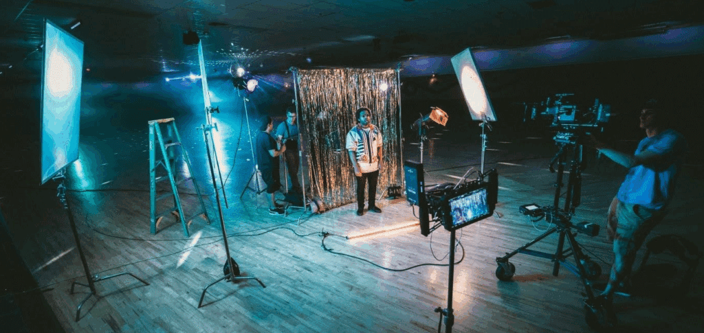 A man surrounded by different lighting rigs on a film set