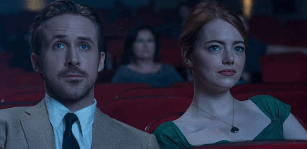 The main characters in La La Land sitting in a movie theater being lit by high-key lighting.