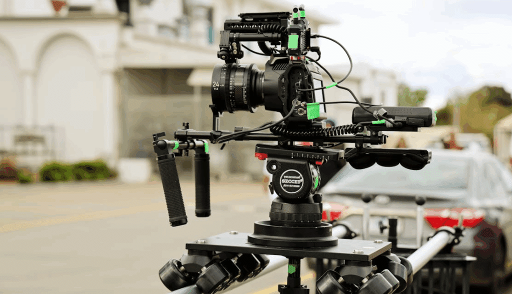 A film camera mounted on a dolly for an outside tracking shot.