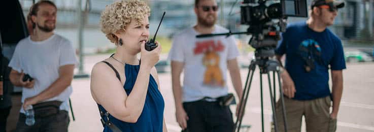 A film director on set, directing a scene with a walkie talkie