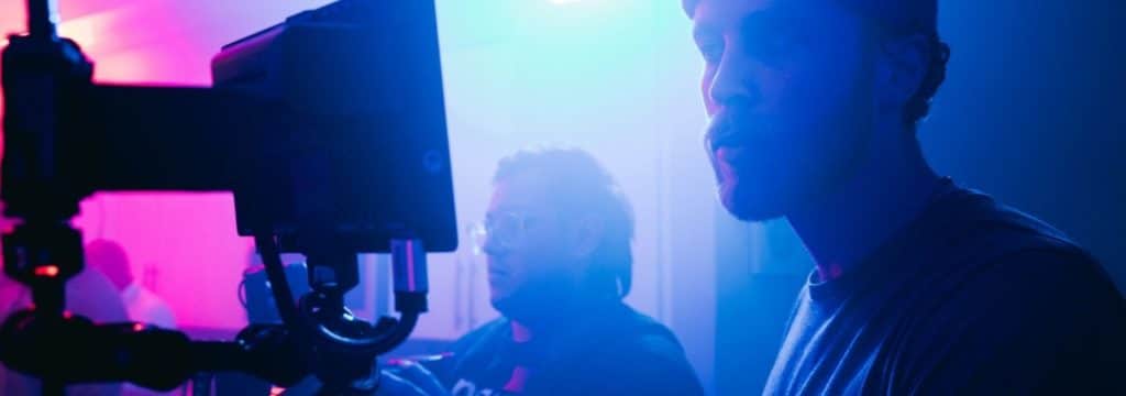 What is screenwriting blog_blue and pink light man stares at monitor on set
