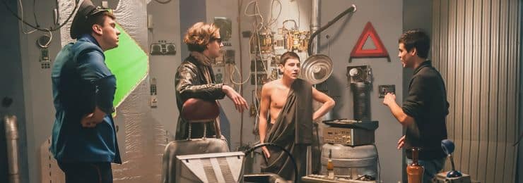 Behind the scenes on a film set showing an executive producer and producer talking to their actors.