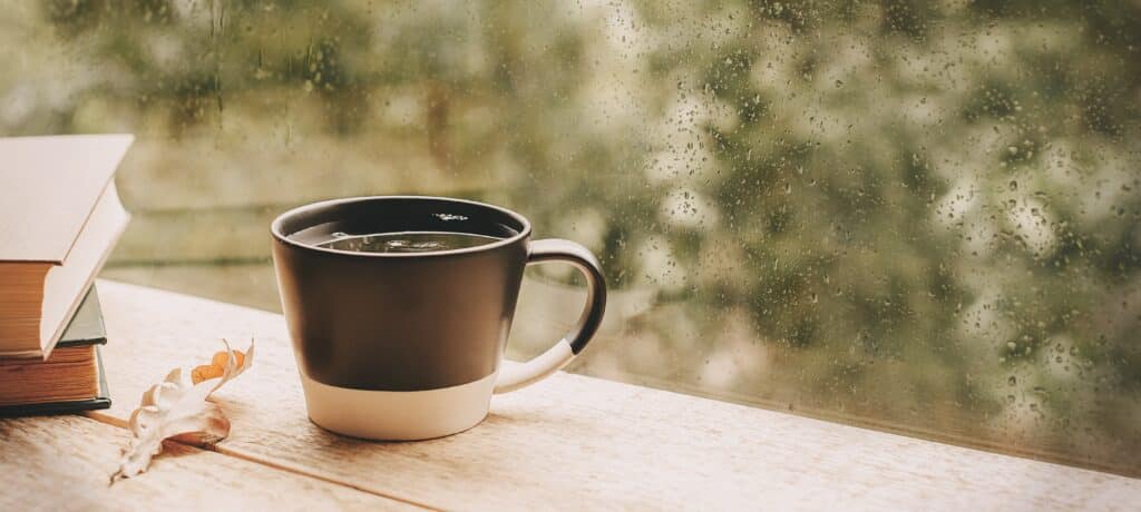 A coffee grows cold next to a rain-slicked window: an example of writing visually