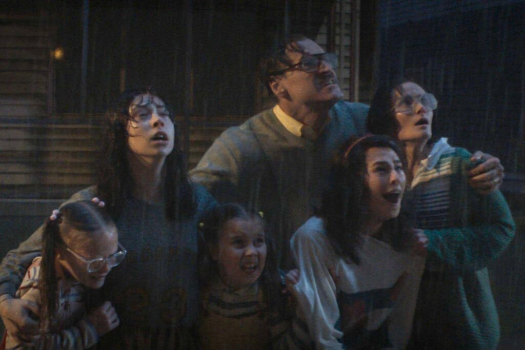 A family stands in the rain, looking at something that must be terrifying. 

A still from the film: The Conjuring