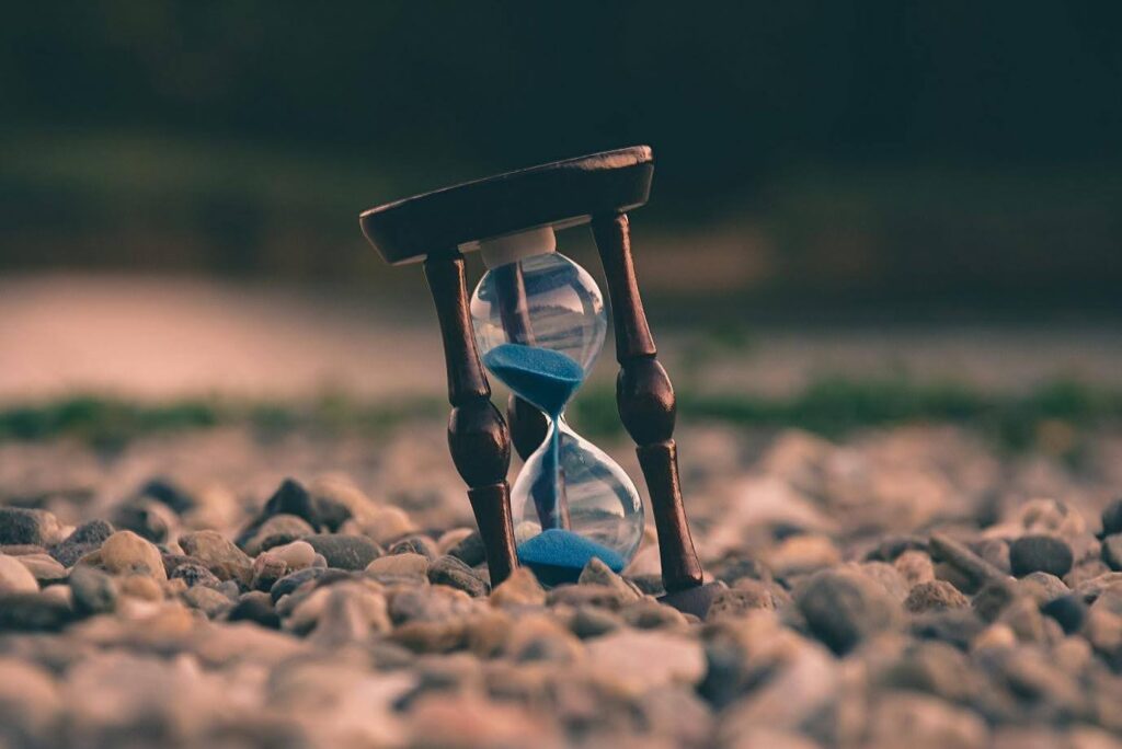 an hourglass sitting in some big rocks