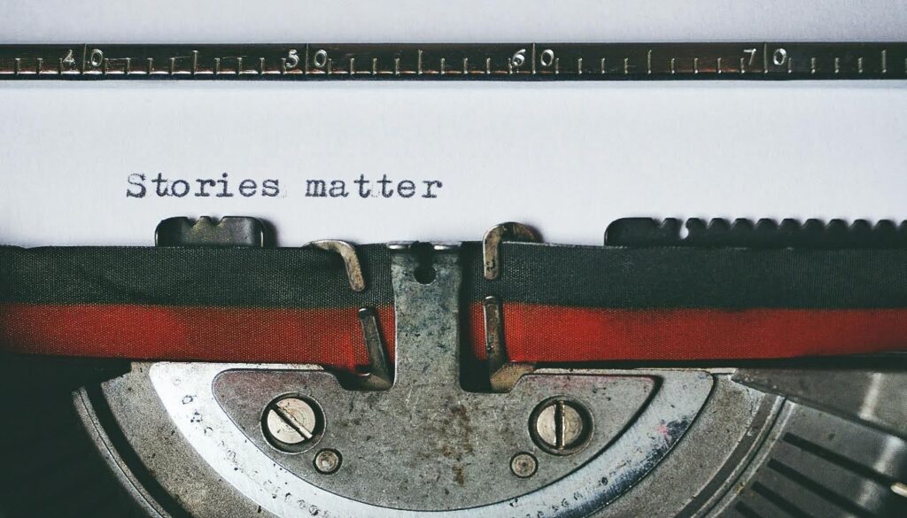 typewriter with a page in it that reads "stories matter"