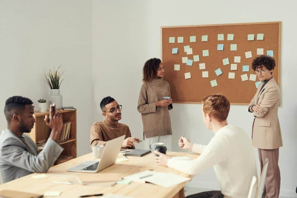 A writer's room discussing story beats pinned on a board.