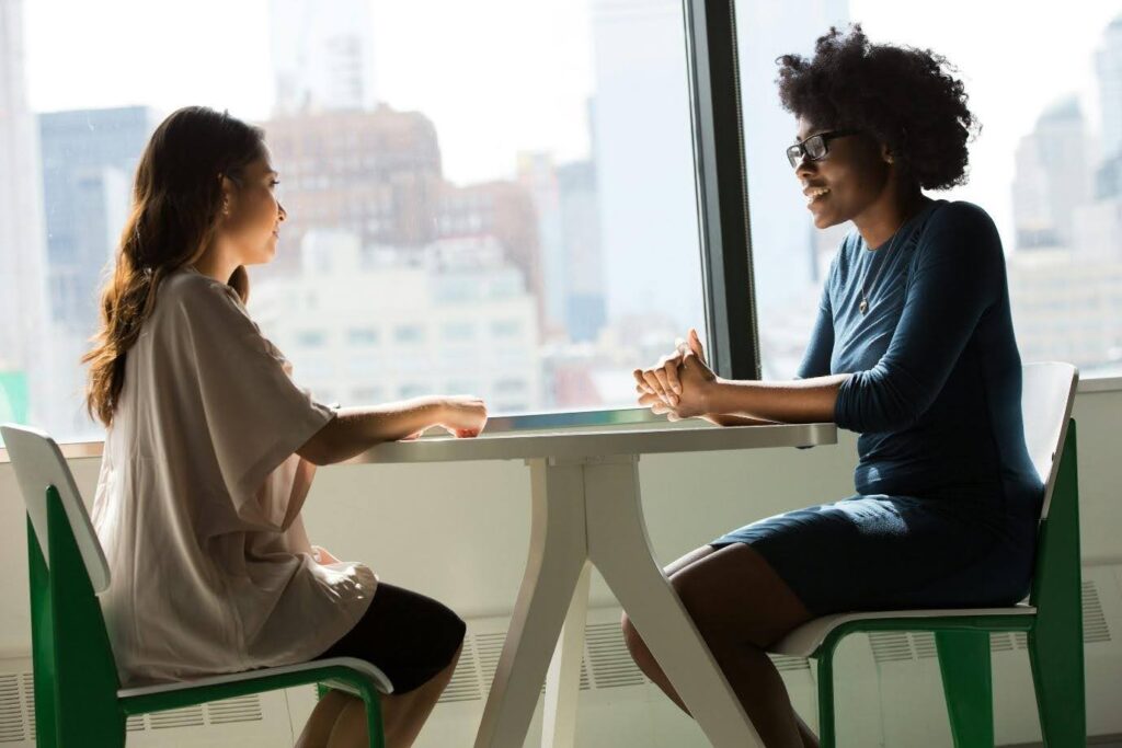 Two women sitting across from one another at a table