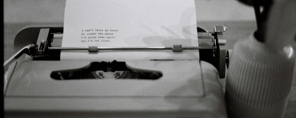 an old typerwrite with a half-written poem coming out of it.