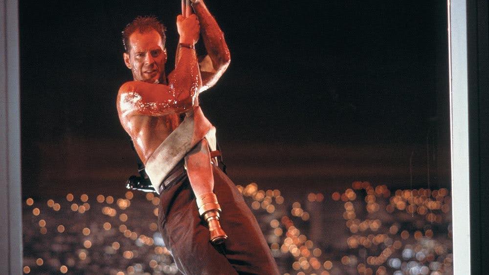John McClane hangs from a fire hose in Die Hard