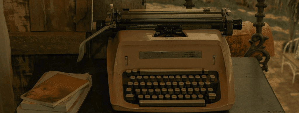 an old typewriter next to a stack of books