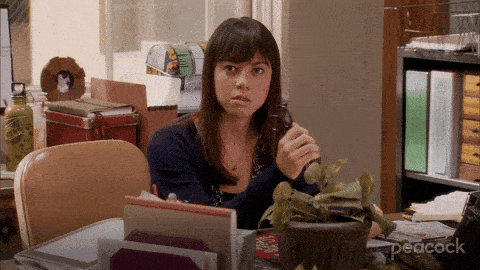 April Ludgate menacingly raises a pair of scissors while staring into the camera.