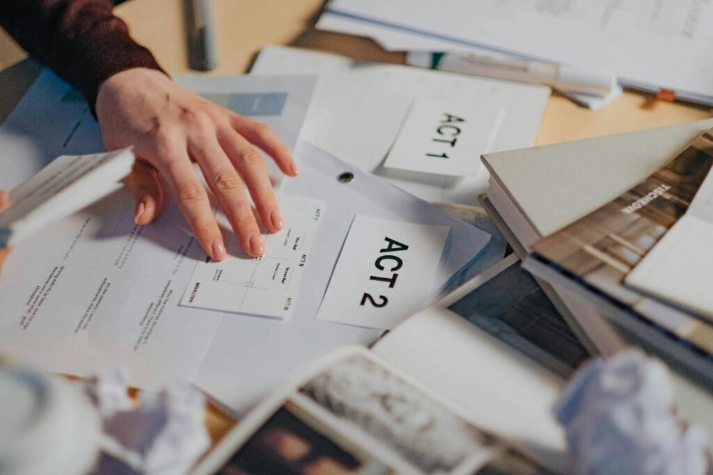 A hand organizes the three acts of a play