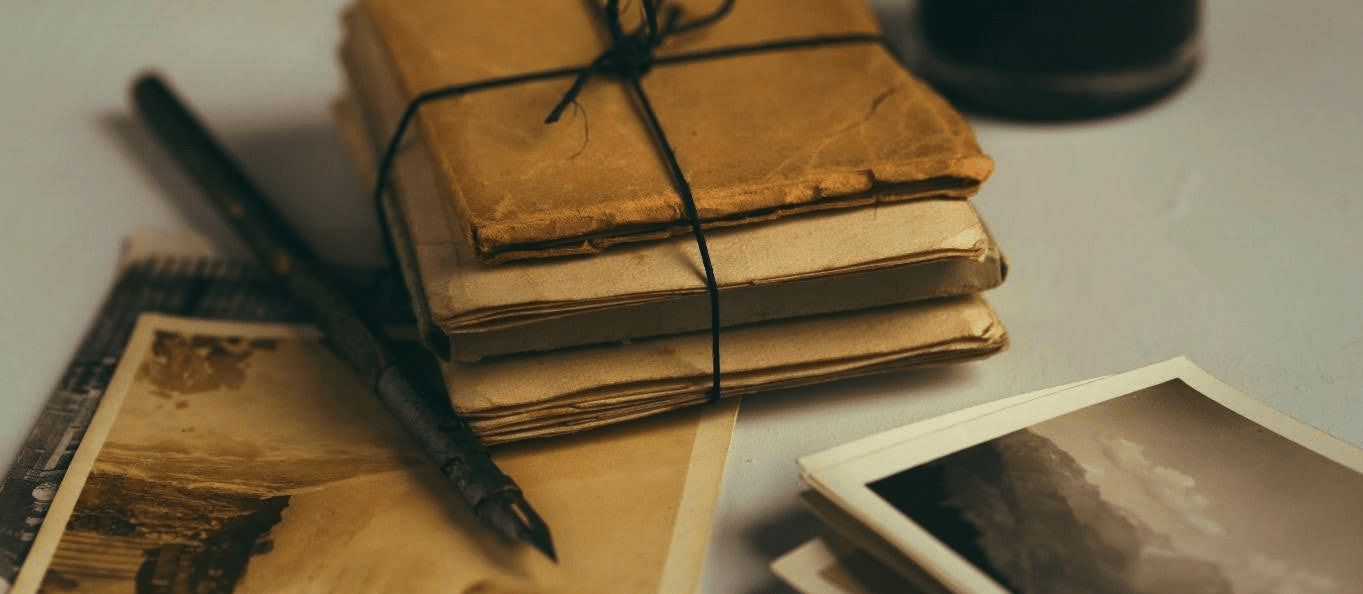 old books, journals, and photos, bound by string.