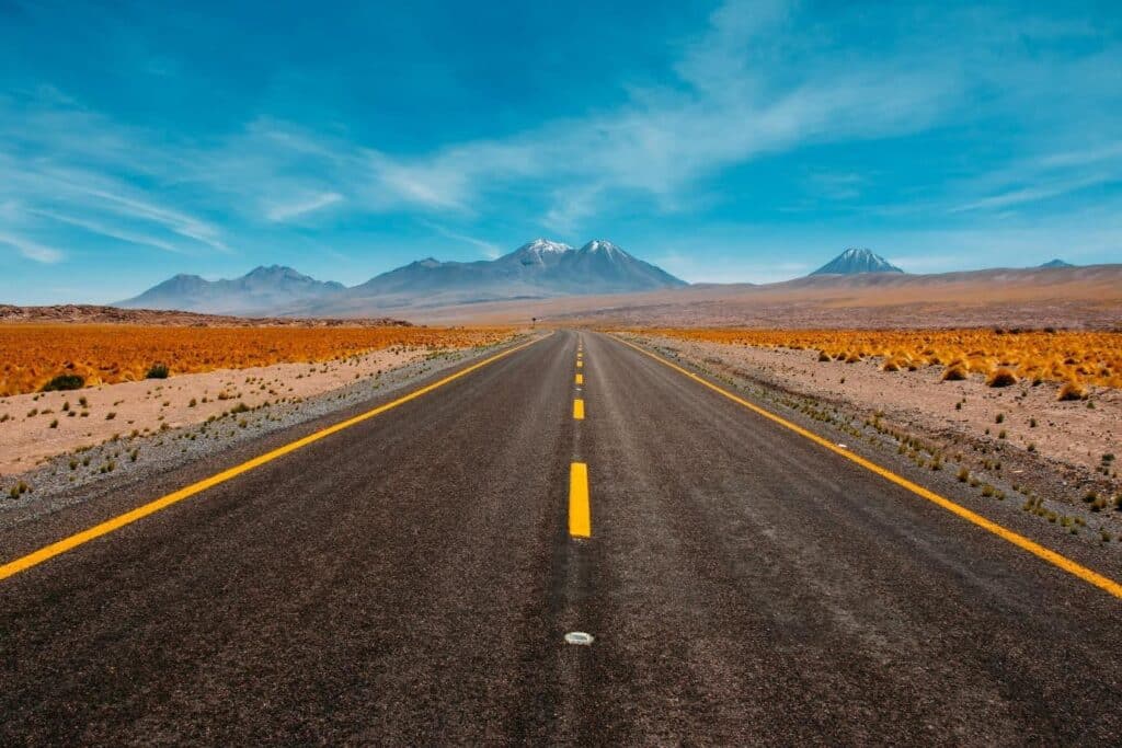 a long road cuts through a barren desert