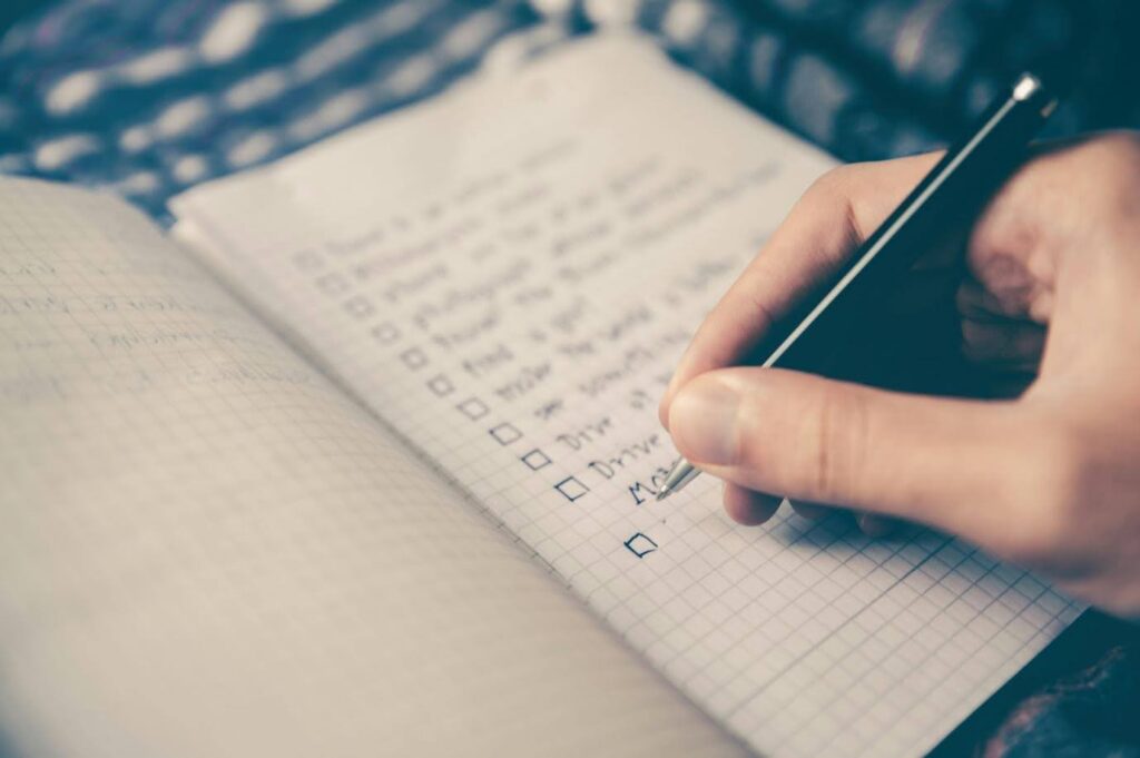 close up of a hand holding a pen, creating a checklist