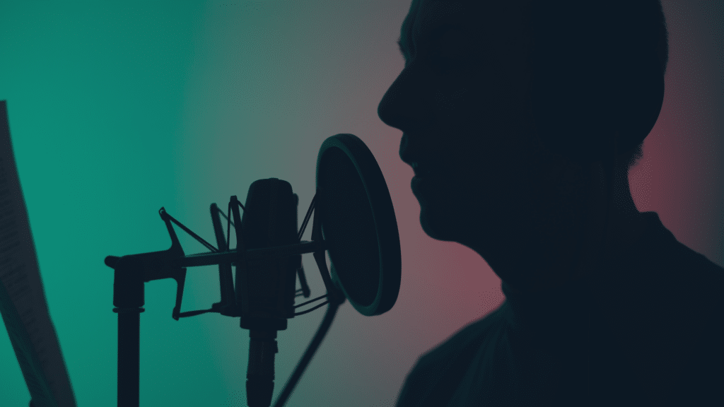 A man speaking into a microphone, perhaps recording a voiceover. Perhaps lending his talents to to AI in film