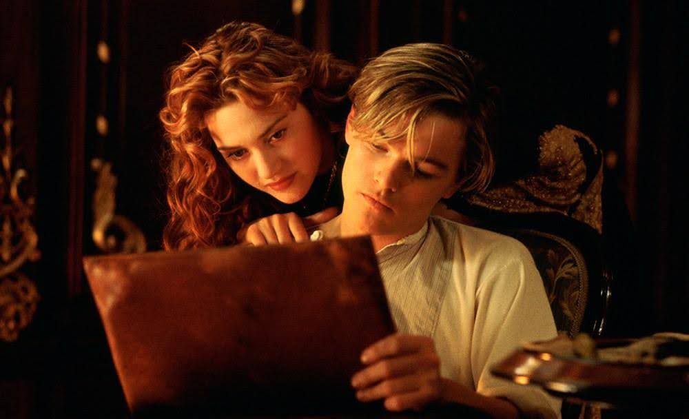 A still from the film Titanic showing Rose watching over Jack's shoulder as he draws. This is part of the Celtex screenwriting series answering the question: how do I write a script?