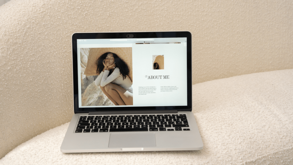 This photo shows a laptop on a cream colored couch with the browser open to what appears to be the "About Me" section of a screenwriting portfolio.