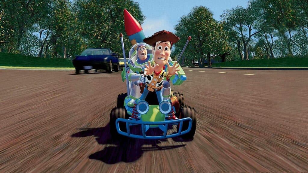 A still from the first Toy Story film. Woody and Buzz ride the toy car to try and catch up with Andy.