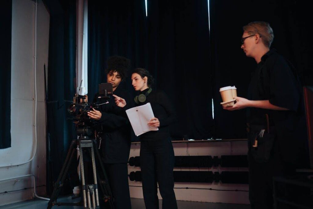 A cinematographer on set instructing the camerawoman how to frame the shot.