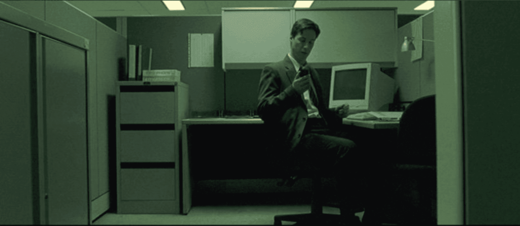Neo in his "normal" desk job, before discovering The Matrix is real.
