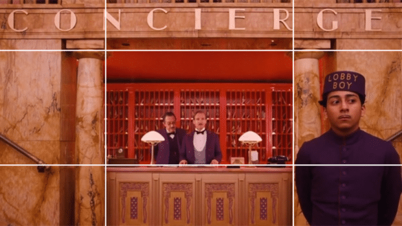 An example of leading lines in film is shown in this still from The Grand Budapest Hotel where the characters and concierge desk are framed perfectly.