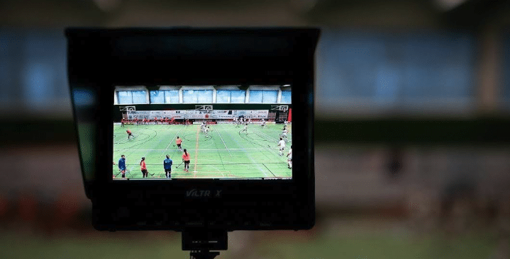 A viewfinder of a camera filming an indoor field hockey match