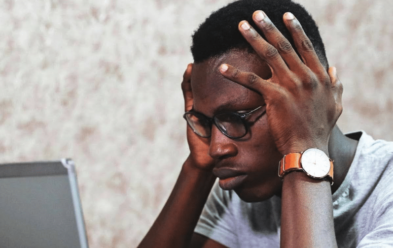 a frustrated screenwriter holds his head in his hands