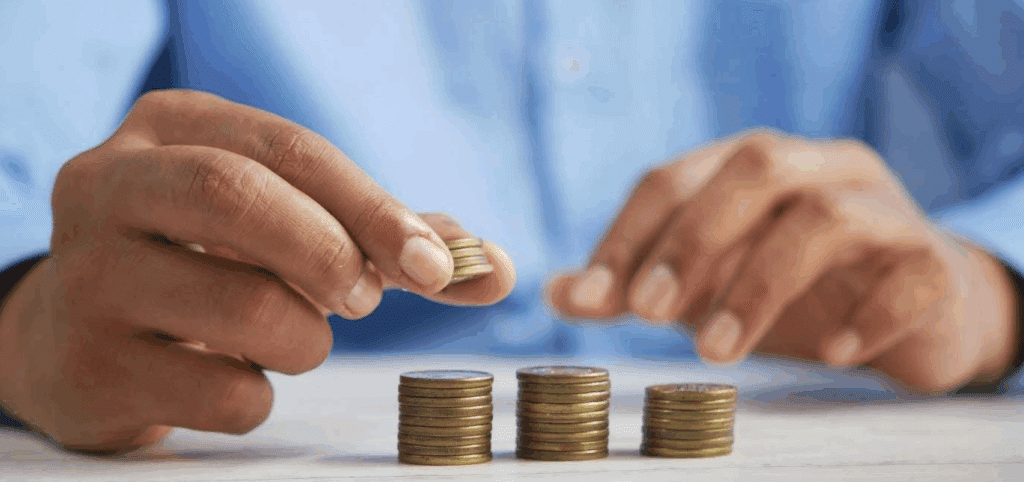 two hands stacking quarters. There are 3 uneven stacks