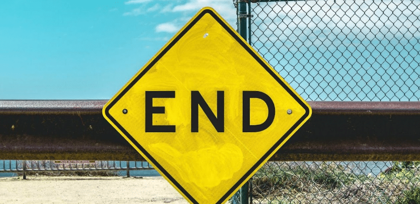 A yellow diamond road sign that reads "END"