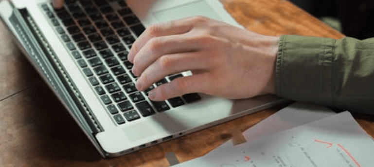 collaborative screenwriting software.

A photo showing hands typing on a laptop with a marked-up script next to the keyboard.