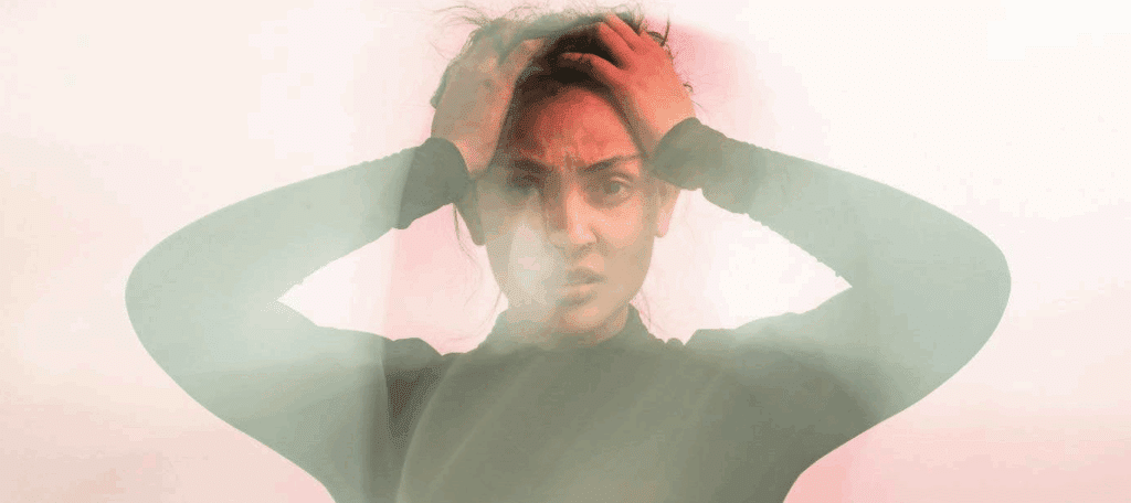 A frustrated looking woman with her hands in her hair.