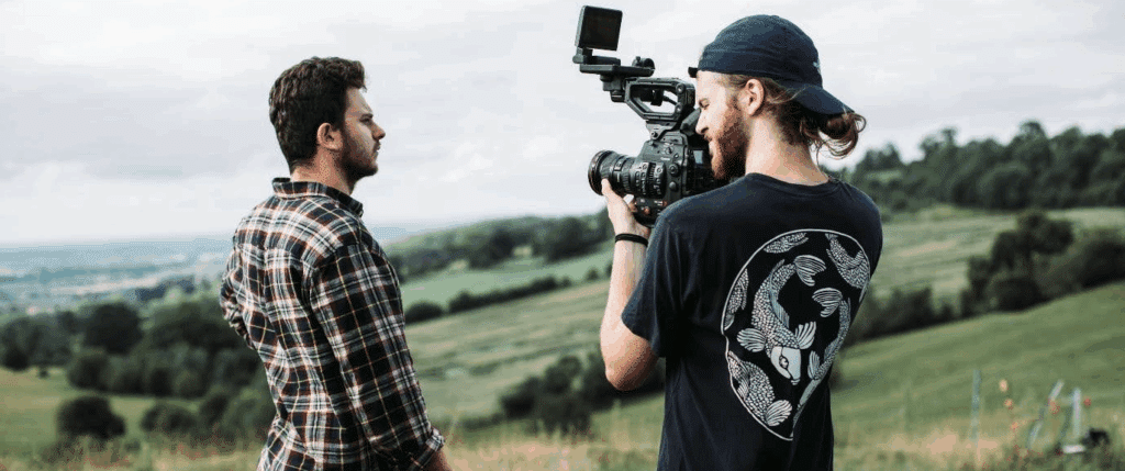 one man films another man in a field