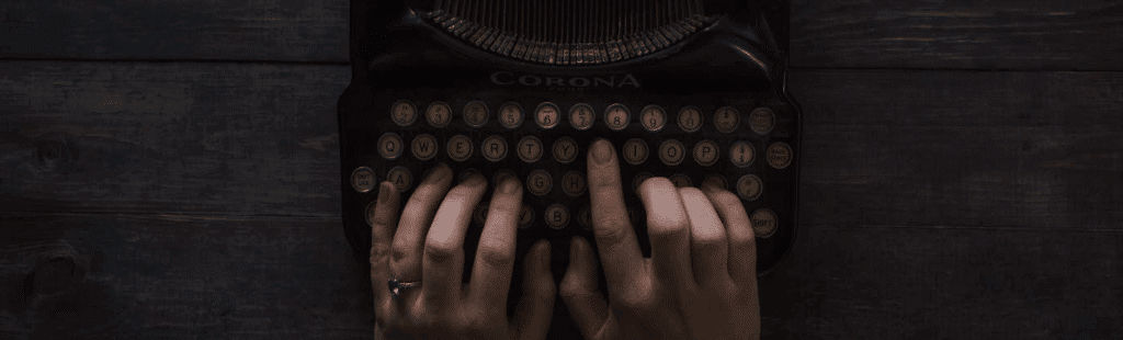 two hands typing on a typewriter