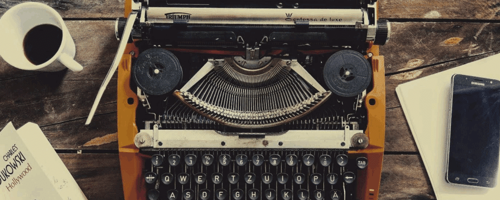 An overhead photo of an old typerwrite and a book on Hollywood