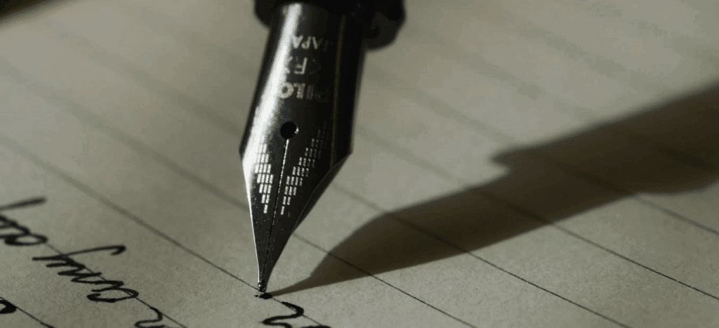 an old fountain pen writing with ink