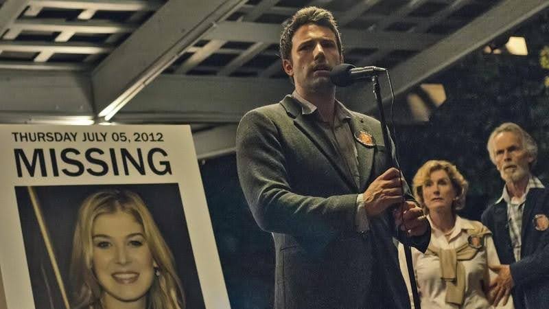 Ben Affleck's character in Gone Girl in front of his wife's missing poster.