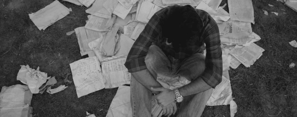A man sitting on a pile of crumpled paper