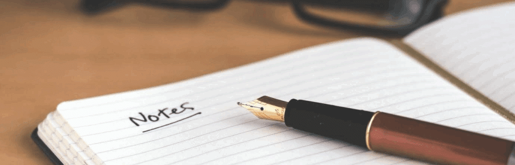 an open notebook and an ink pen