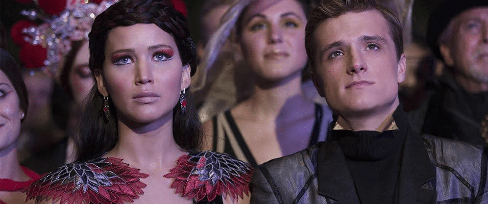 Katniss and Peeta look on at the capitol - they live in a dystopian world.