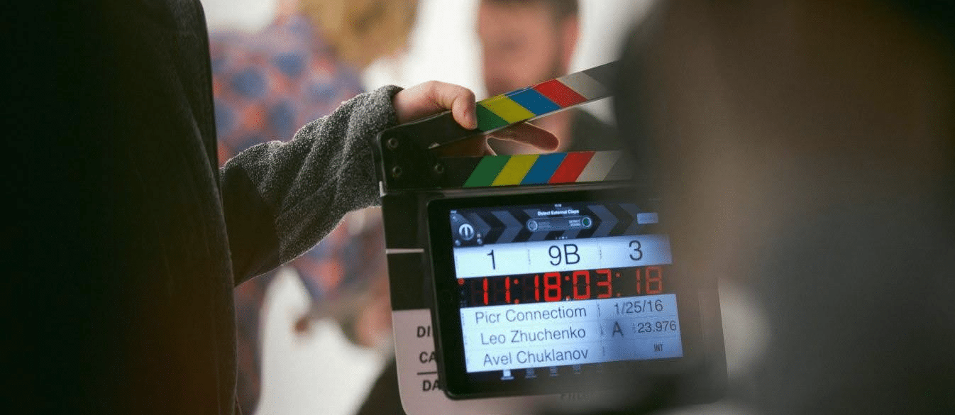 A clapboard on the set of a film, open and ready to shut and begin filming a scene