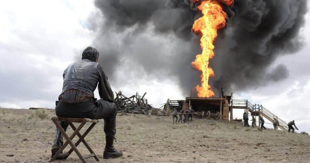 Daniel Plainview stares on as men work on an oil derrick