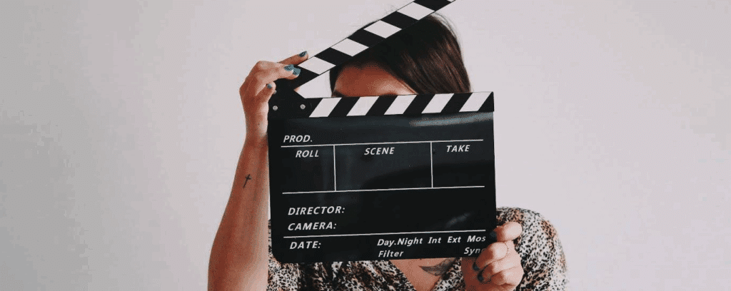 A person behind an open (and blank) clapboard