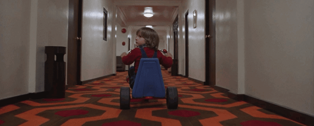 Danny rides his Big Wheel through the hallways of The Overlook Hotel - the story setting of The Shining