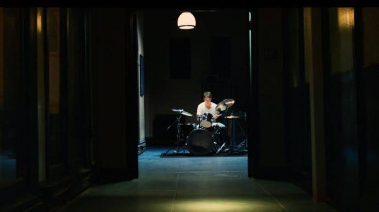 main character in the film Whiplash playing drums in the conservatory - the setting of the film