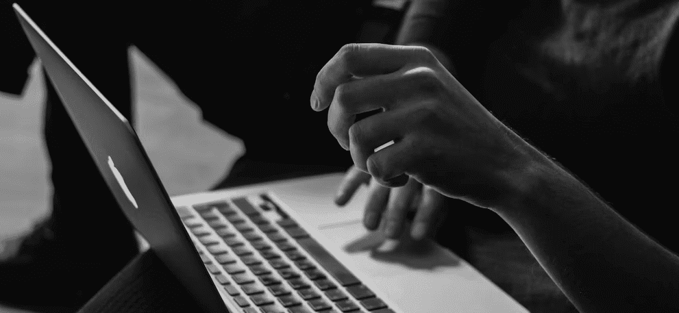 black and white photo of a person using a laptop