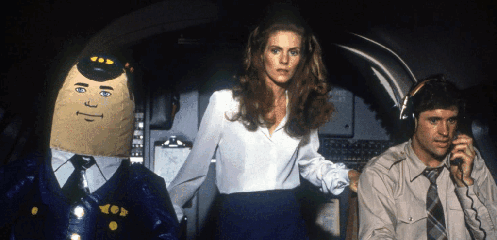 The main characters of the film Airplane! in the cockpit. With the potato looking blowup co-pilot.