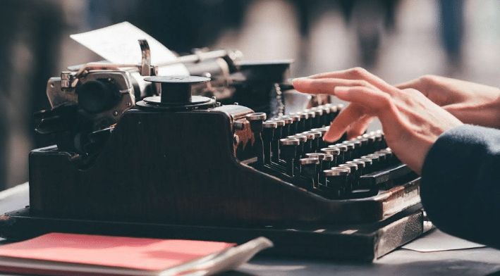 hands typing on a typewriter